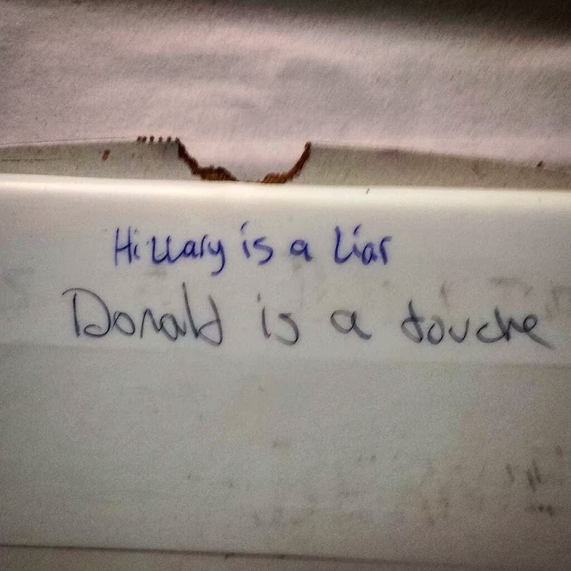 scrawled handwritten graffiti on a wall.